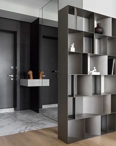 a room with a book shelf, sink and mirror on the wall next to it