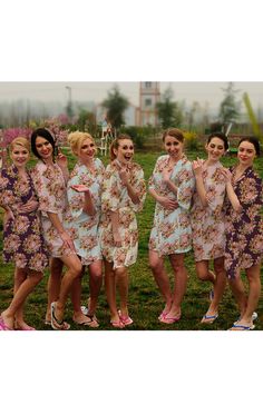 a group of women standing next to each other on top of a lush green field