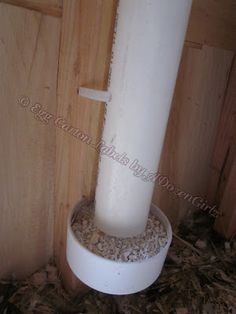 a tall white pillar sitting on top of a pile of wood shaving next to a door