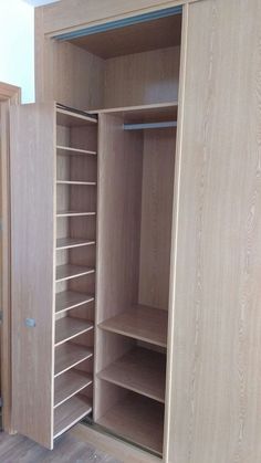 an empty closet with wooden shelves and drawers