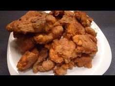 fried chicken on a white plate sitting on a table