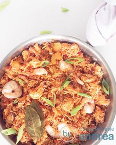 a bowl filled with rice and shrimp on top of a table