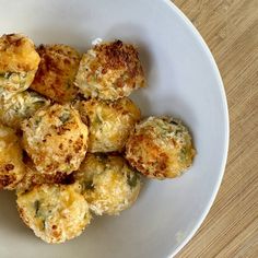 a white bowl filled with fried food on top of a wooden table