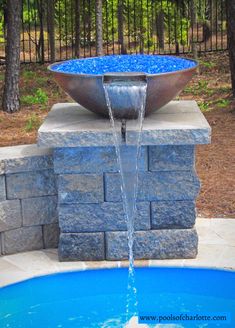 a bowl shaped fountain in the middle of a pool with water coming out of it