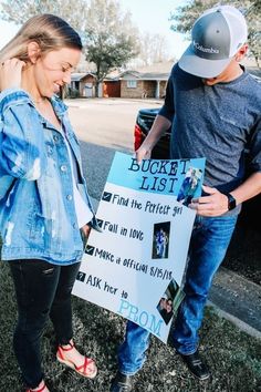 a man and woman standing next to each other with a sign in front of them