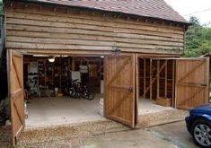 an open garage door with two bicycles parked in the doorway and one car parked outside