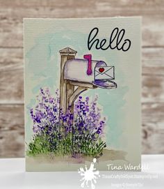 a handmade greeting card with an envelope and purple flowers on the front, in front of a wooden background