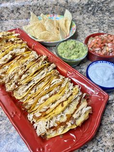 a red platter filled with tacos and chips