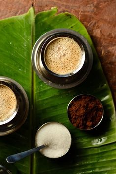 there are three cups on the table with spoons next to each other and spices