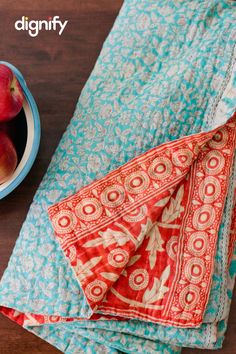 a bowl of peaches sitting on top of a table next to two napkins