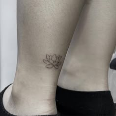 a small lotus tattoo on the ankle