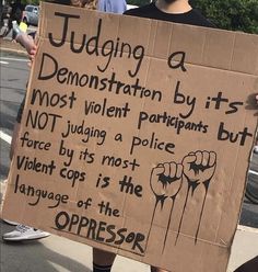 a protester holding a sign that reads judging a demonstration by its most violent participants