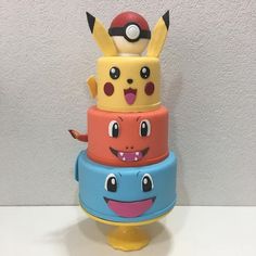 a stack of three different colored pokemon themed cakes