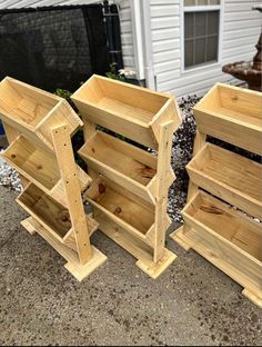 three wooden shelves sitting next to each other in front of a white house on the sidewalk