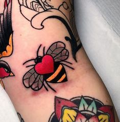 a close up of a person's leg with tattoos on it and a bee