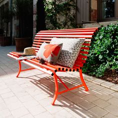 an orange bench with two pillows on it