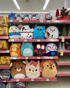 several stuffed animals are on shelves in a toy store, one is blue and the other is red