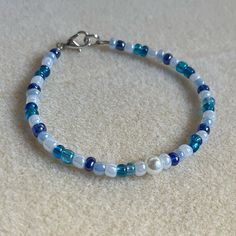 - One Of A Kind Beaded Bracelet - Featuring White, Light Blue, Dark Blue, And Translucent Blue Seed Beads, And White Pearl Center - Silver Colored Hardware - Clasps Closed. No Stretch. - Size/ Circumference Is 7.5” (See Picture) - Handmade (By Myself). Perfect To Treat Yourself Or To Give As A Gift! **Add 2 Jewelry Items Marked “2 For $20” To Your Bundle And I Will Send You An Offer For $20** Check Out The “Boutique” Tab In My Closet For Handmade Earrings, Bracelets, And Necklaces! Beads Bracelet Design Blue, Light Blue Beaded Bracelets, Bracelet Inspo Seed Beads, Blue Seed Bead Bracelet, Bracelet Ideas Seed Beads, Beaded Bracelets Blue, Cute Beaded Bracelets, Blue Friendship Bracelet, Blue And White Bracelet