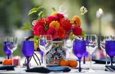 the table is set with colorful flowers and wine glasses for an elegant dinner or party