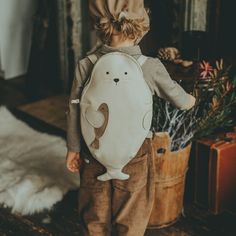 a little boy that is standing up with a stuffed animal in his back pocket and the caption says, donnise