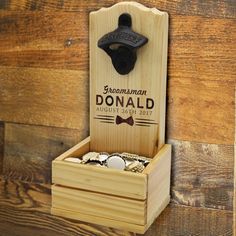 a bottle opener is mounted to the side of a wooden box with money in it