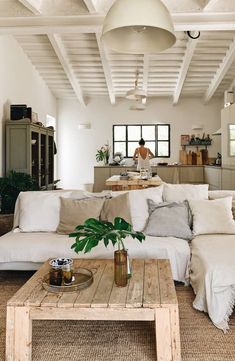 a living room filled with furniture and a wooden table in front of a white couch