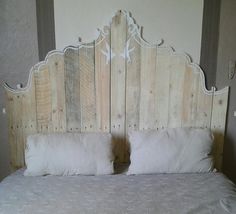 a bed made out of wood with two white pillows on top of the headboard