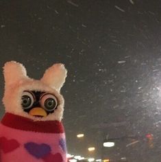 a stuffed animal is wearing a sweater with hearts on it's chest and eyes