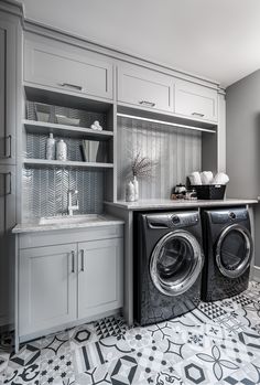 a washer and dryer sitting in a kitchen next to each other on top of a tiled floor