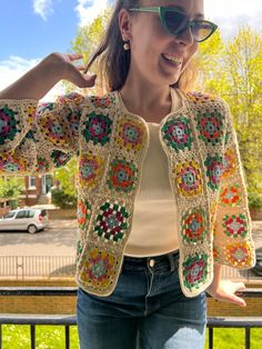 a woman wearing sunglasses and a crocheted jacket