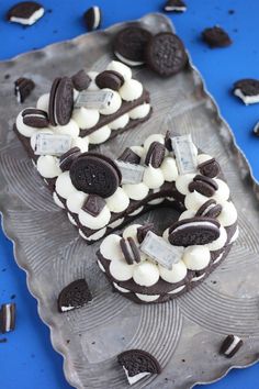 oreo cookies and cream sandwiches are on a cookie sheet with chocolate chips scattered around them