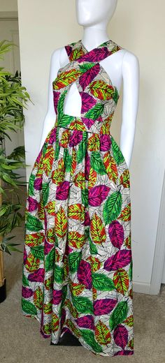 This handmade women's dress features a beautiful colorblock African print in multicolor polyester. The dress has a halter neckline, sleeveless design, and a zipper closure. It comes in size M, L and XL and is perfect for weddings, parties, casual or workwear occasions.  The dress is made with woven fabric and has a fit & flare, shift, maxi style. It has an empire waist, cut out, keyhole neck, and high waist features. Ideal for summer, fall, or spring, this dress is a must-have for any beach-themed event. Care instructions: no bleaching, wash with likes colors on a gentle circle, dry on low to medium heat.  Let us introduce you to our colorful world of beautiful African print fabric! Their unique patterns and vibrant colors help you feel instantly happier, which is why we love using them to Summer Sleeveless Dress With Bold Print, Sleeveless Multicolor Tropical Print Midi Dress, Sleeveless Multicolor Midi Dress With Tropical Print, Sleeveless Multicolor Dress With Tropical Print, Multicolor Sleeveless Dress With Tropical Print, Green Printed Halter Neck Maxi Dress, Green Tropical Halter Neck Dress, Multicolor Floral Print Halter Neck Dress, Multicolor Tropical Print Halter Neck Dress