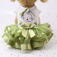 a teddy bear wearing a green tutu skirt