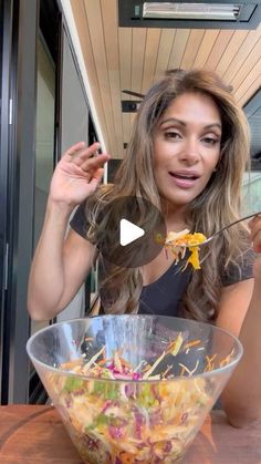 a woman is eating salad out of a bowl