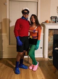 a man and woman in costumes standing next to each other on a hard wood floor