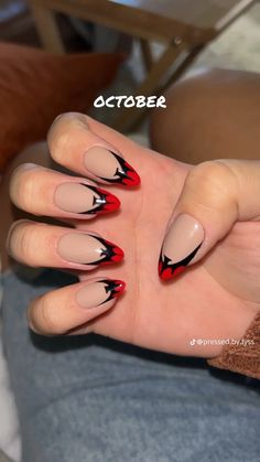 a woman's hand with red and black nail polish on it, which has an arrow