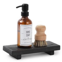 a bottle of hand soap next to a wooden shaving brush