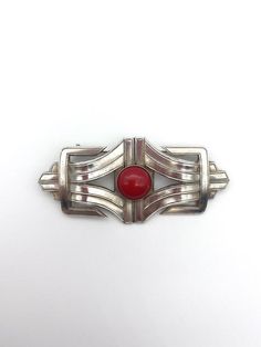 A modernist inspired Art Deco brooch made from two art deco stampings that were produced in an old factory in Paris that closed down several years ago.The brooch is set with an Opaque red glass stoneIt is made from solid brass which has been 5 micron silver plated and has a high quality pin on the reverse with a roll type safety catch. Retro Red Brooch Jewelry, Red Retro Brooch Jewelry, Art Nouveau Necklaces, Art Deco Brooch, Old Factory, Dog Brooch, Scottie Dog, Red Glass, Silver Fashion