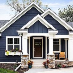 a blue house with white trim and two front porches on the first floor is shown