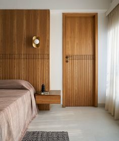 a bed sitting next to a wooden door in a bedroom on top of a white floor