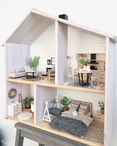 a doll house is shown with furniture and accessories on the shelves in front of it