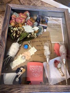 a wooden box filled with lots of different items and flowers on top of a table