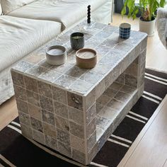 a coffee table with two bowls on it in the middle of a living room area