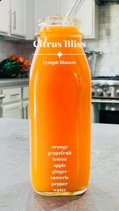 a glass jar filled with orange liquid on top of a counter