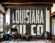 a living room with a large sign on the wall next to a chair and ottoman