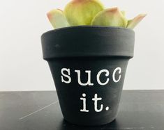 a succulent plant with the words succ it written in white on a black pot