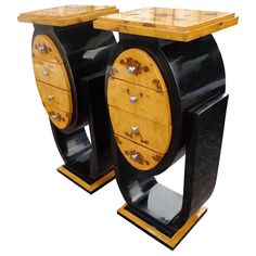 two black and gold side tables with drawers on each end, one is shaped like a barrel