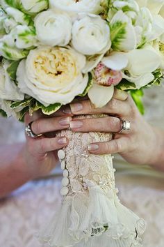 the bride's bouquet is being held by two hands