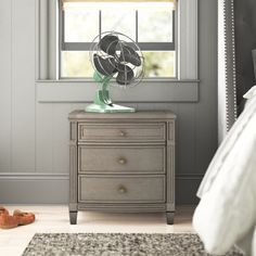 a bedroom scene with focus on the dresser and fan