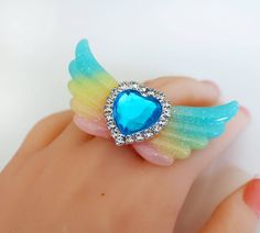 Resin Glitter Ring - Glitter Wings Jewelry - Glitter wings ring - Heart Ring - Kawaii Ring - Valentine Gift - Heart Wing Jewelry-Kawaii Ring - Harajuku Fashion - fairy Tale Jewelry this listing is for a lovely angel wings ring with a beautiful heart in the middle. The ring is handmade out of resin. You will get exactly the same as shown on the picture. The pink filigree ring is adjustable. The wings are 7 cm large (2.5 inch) some parts are not compatible with water and shouldn't be submerged. ju Cute Heart Ring For Gift, Cute Adjustable Party Rings, Adjustable Cute Party Rings, Cute Adjustable Rings For Parties, Cute Party Ring Jewelry, Angel Wings Ring, Kawaii Ring, Mode Harajuku, Wings Jewelry